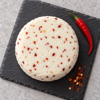 Niewędzony ser podpuszczkowy z chilli 350g na ciemnej kamiennej płycie